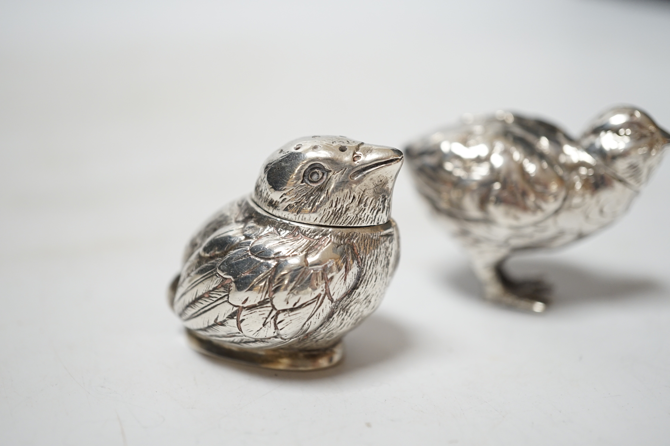 Two novelty silver pepperettes, modelled as chicks, the smallest with import marks for London, 1925, the other with import marks, but no date letter.